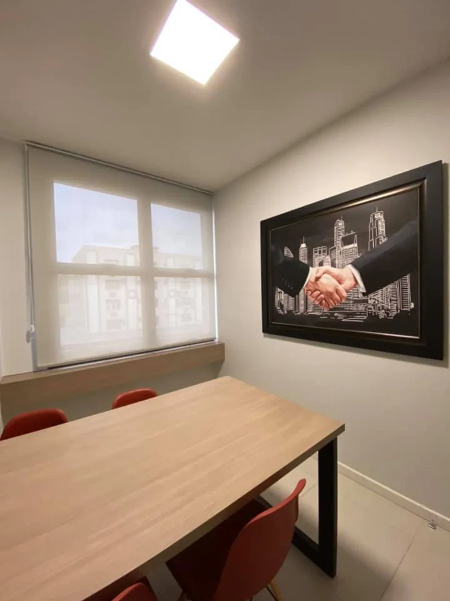 Sala de reunião com quadro decorativo e vista para a janela