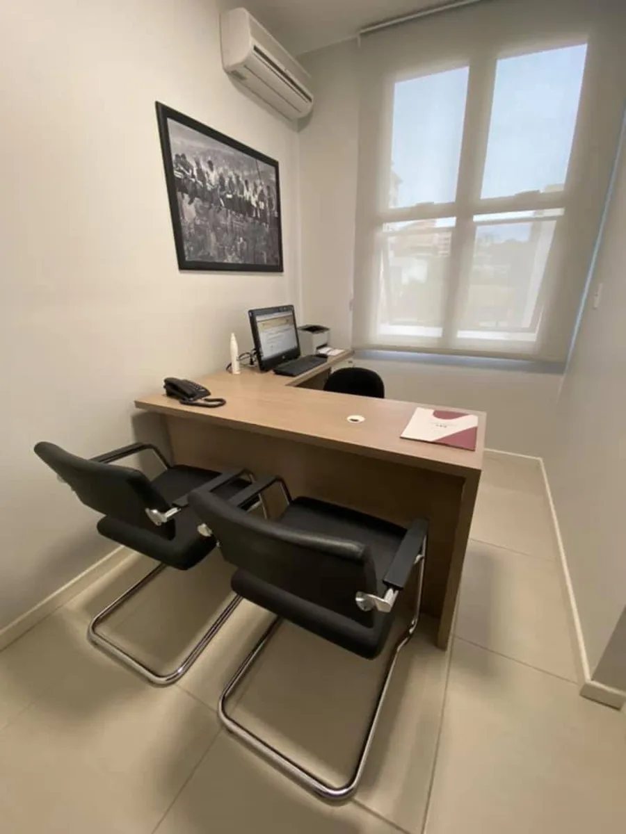 Sala de atendimento com mesa de trabalho e luz natural