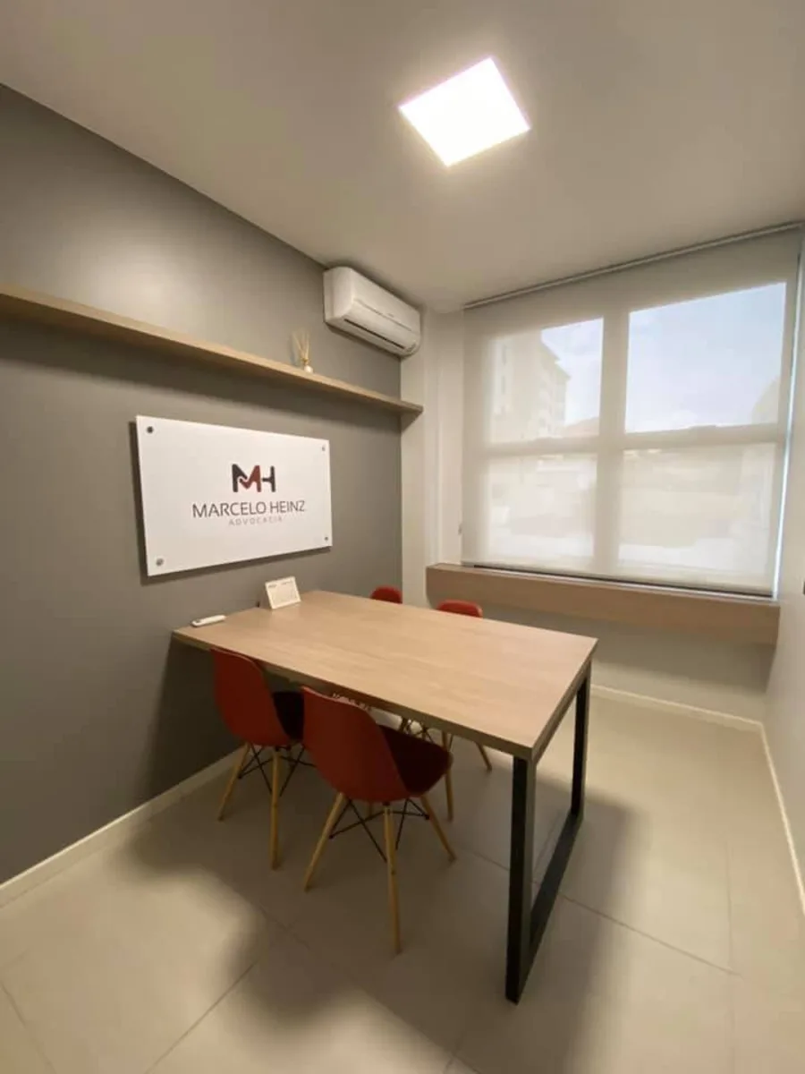 Sala de reunião com mesa de madeira e cadeiras terracota