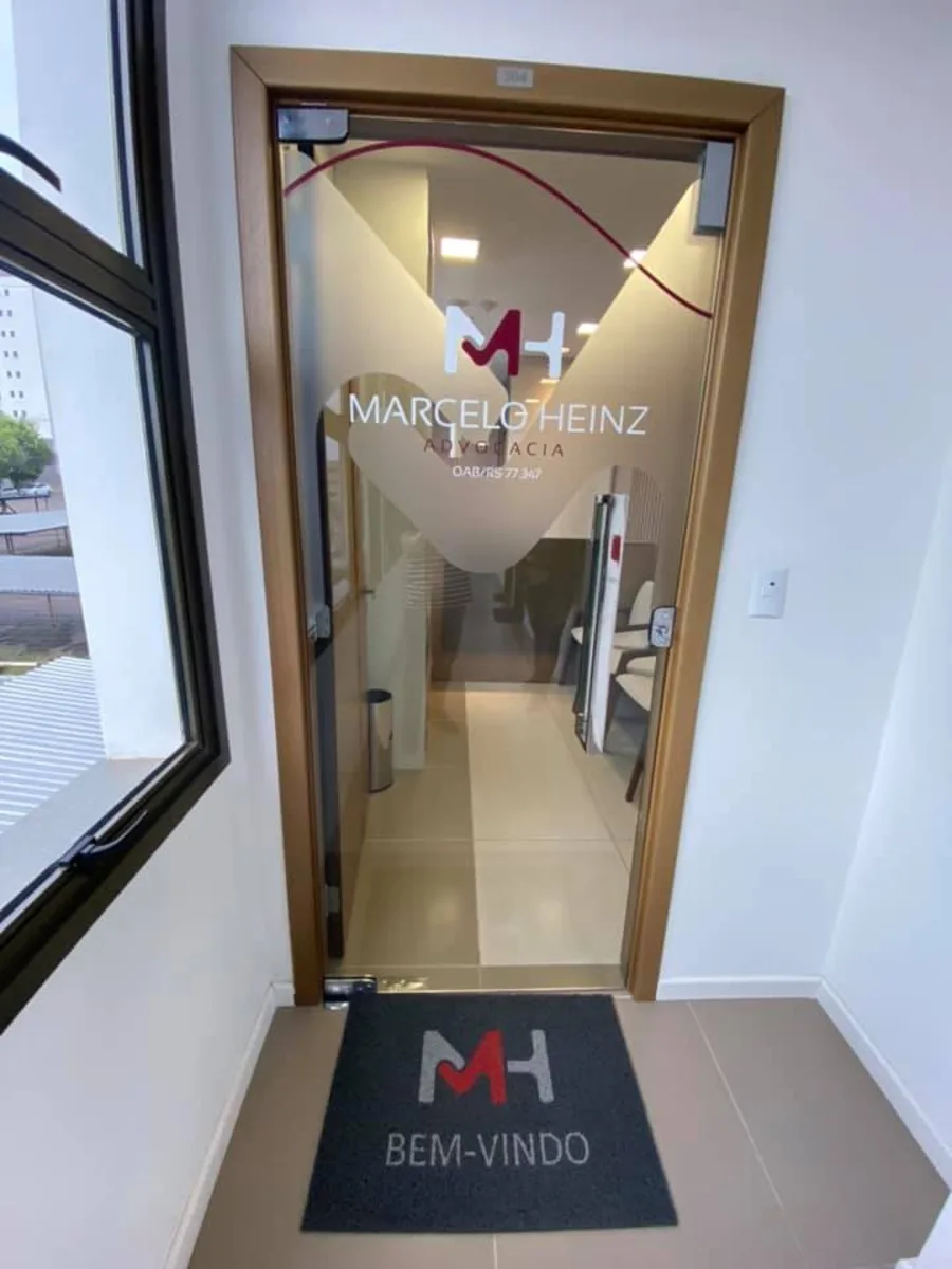 Entrada do escritório com porta de vidro e a logomarca aplicada